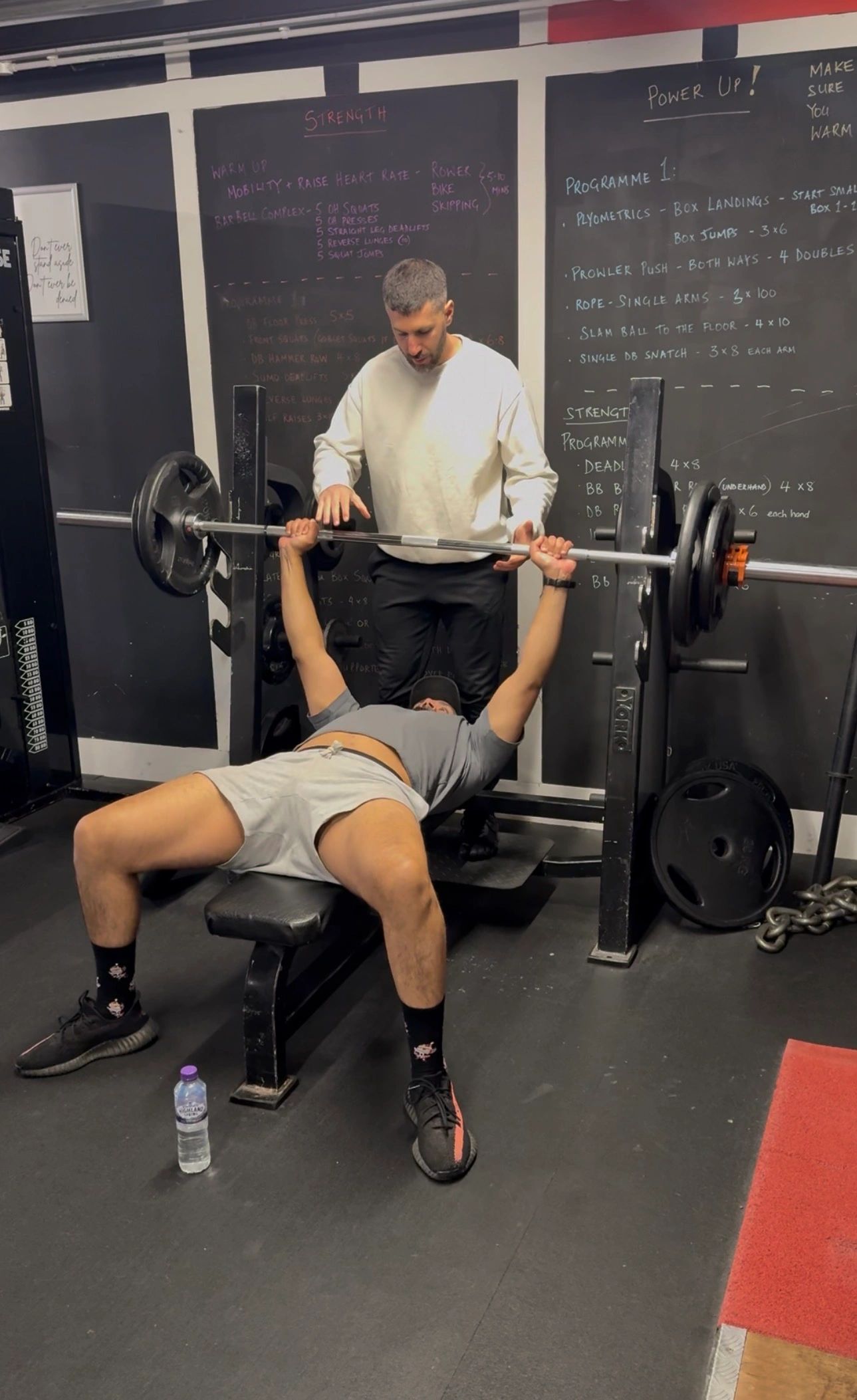 Alexandros coaching a client through a bench press