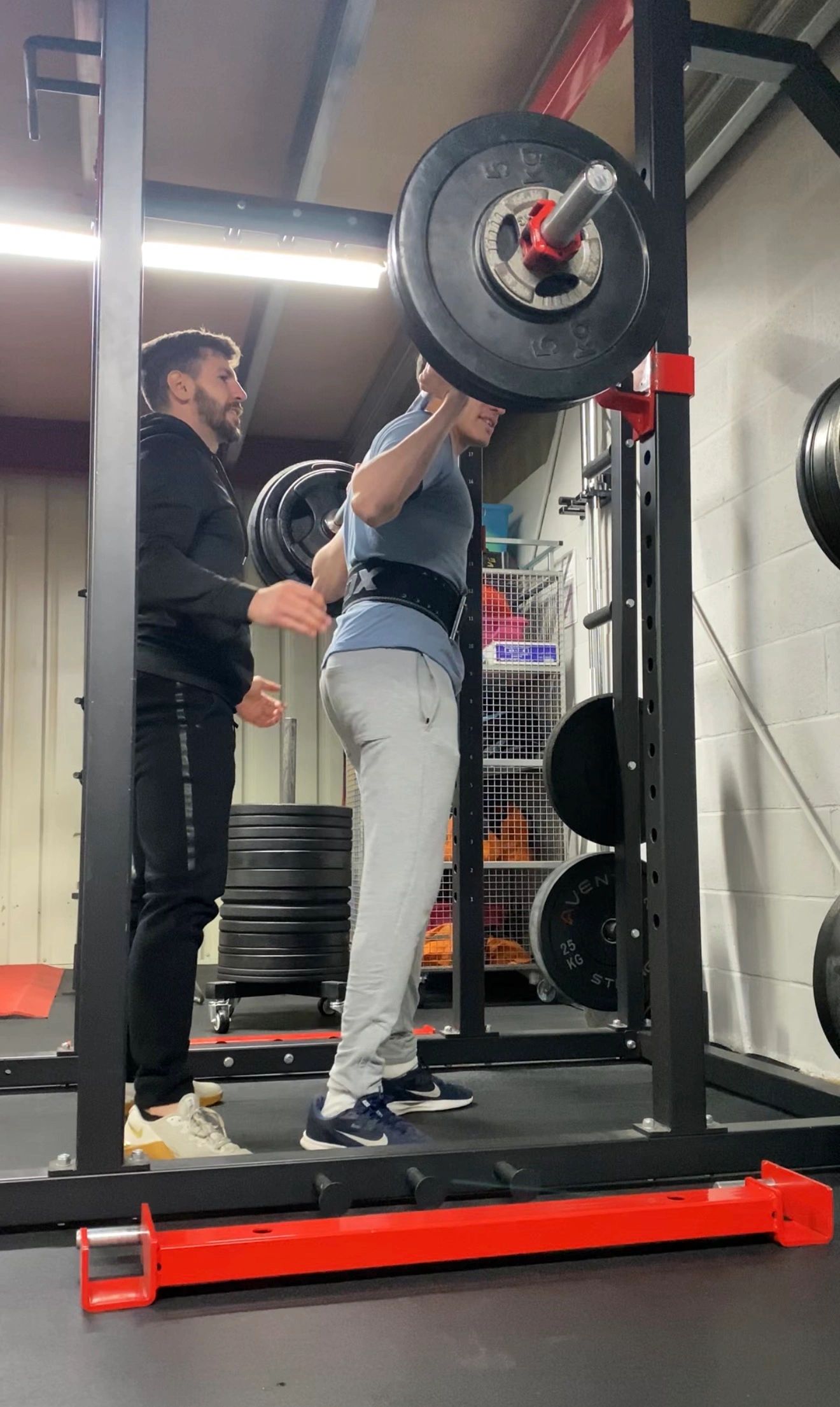 Alexandros spotting a client during a barbell squat