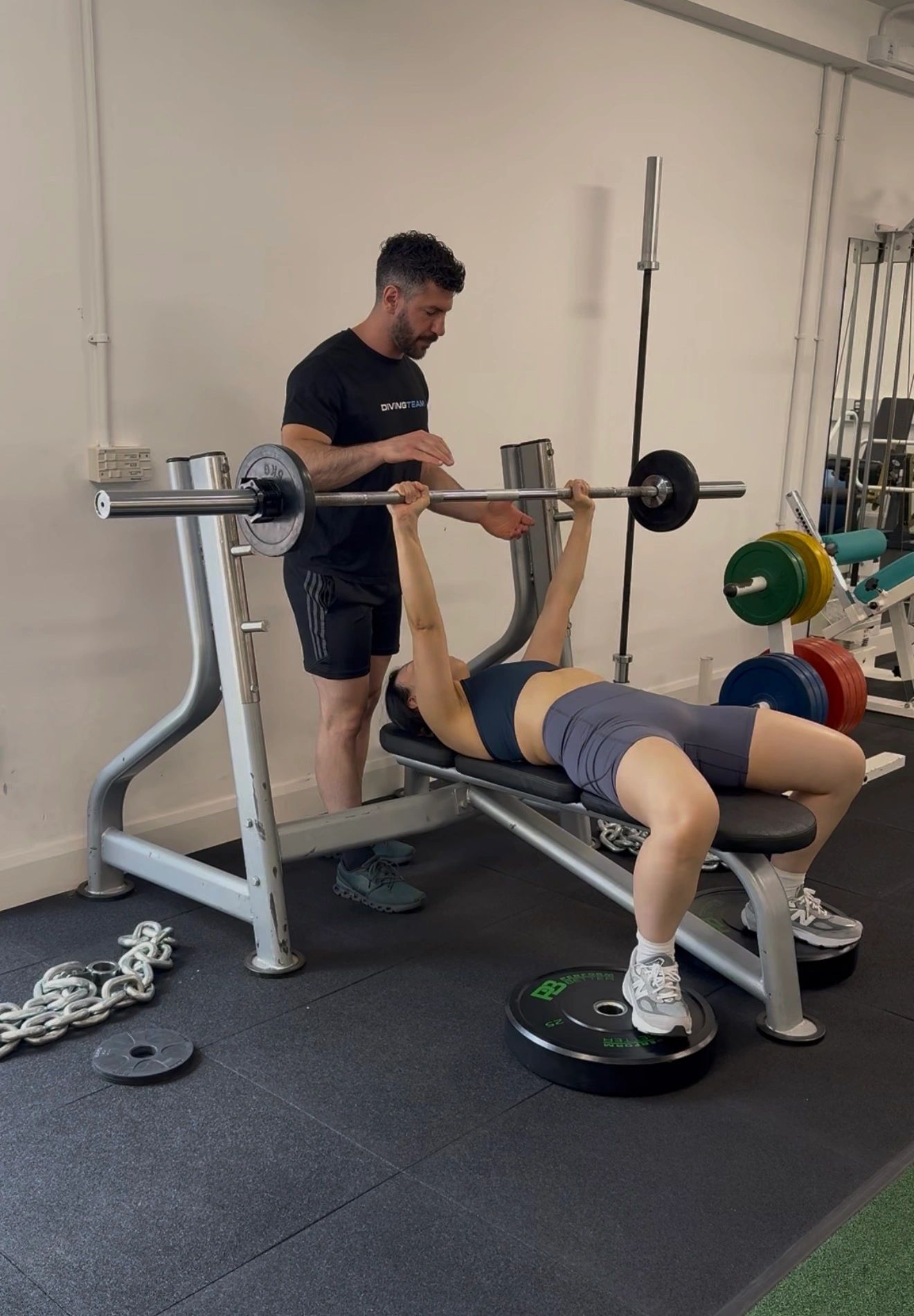 Alexandros coaching a client using gym equipment